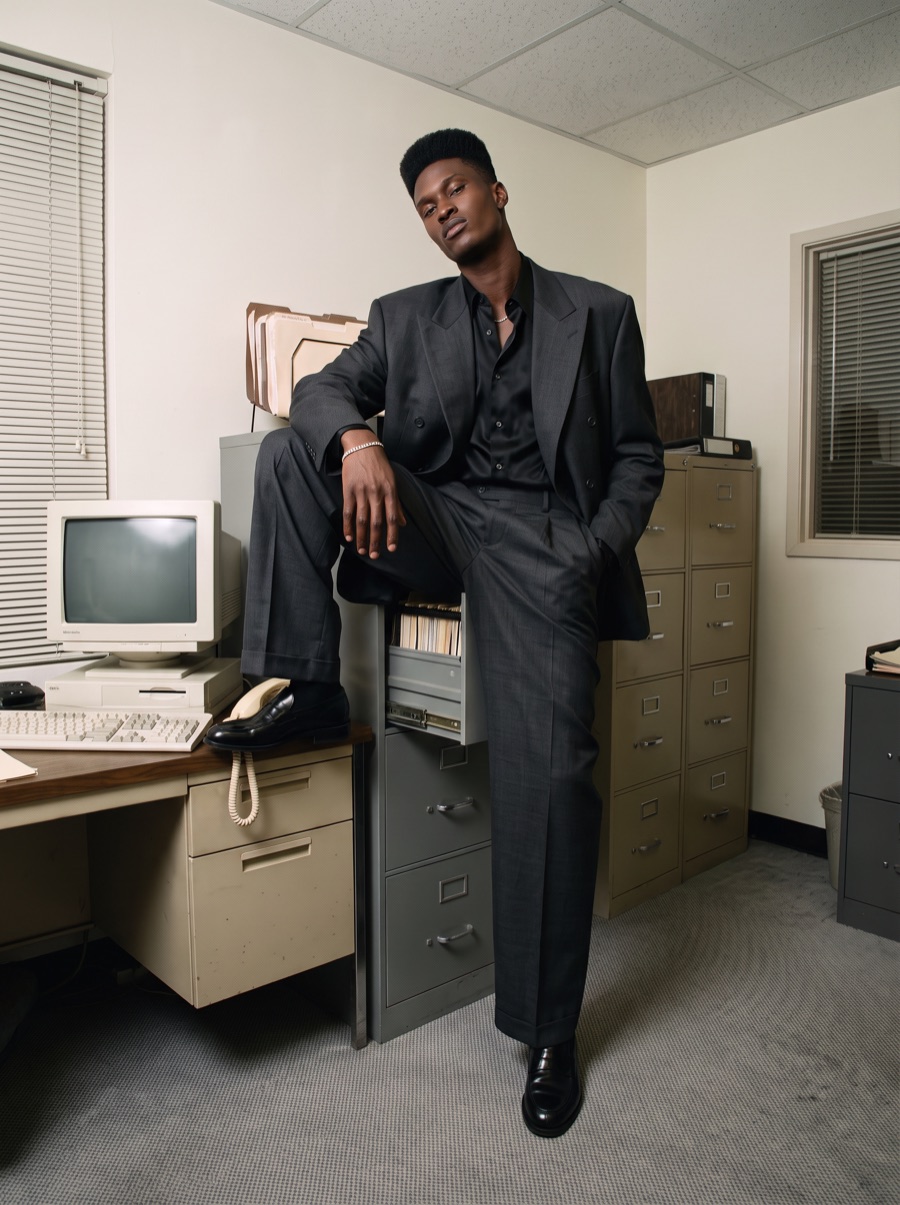 A founder with one foot up on a filing cabinet in a beige office