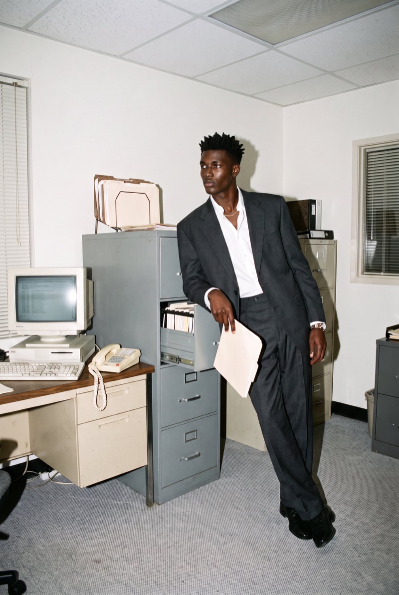 Sam leaning on a filing cabinet