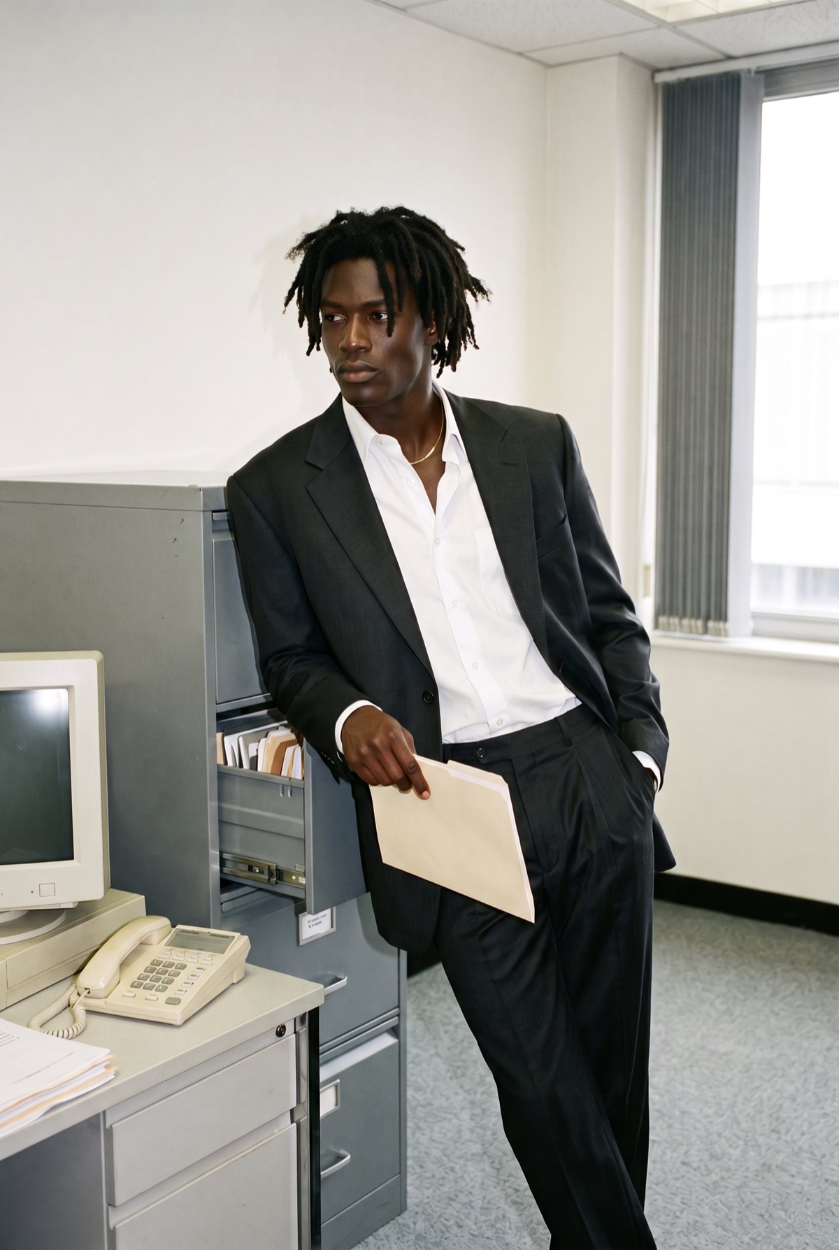 A founder leaning on a filing cabinet